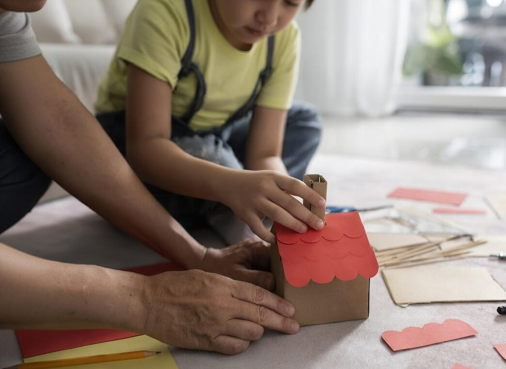 Parent and child building a craft house